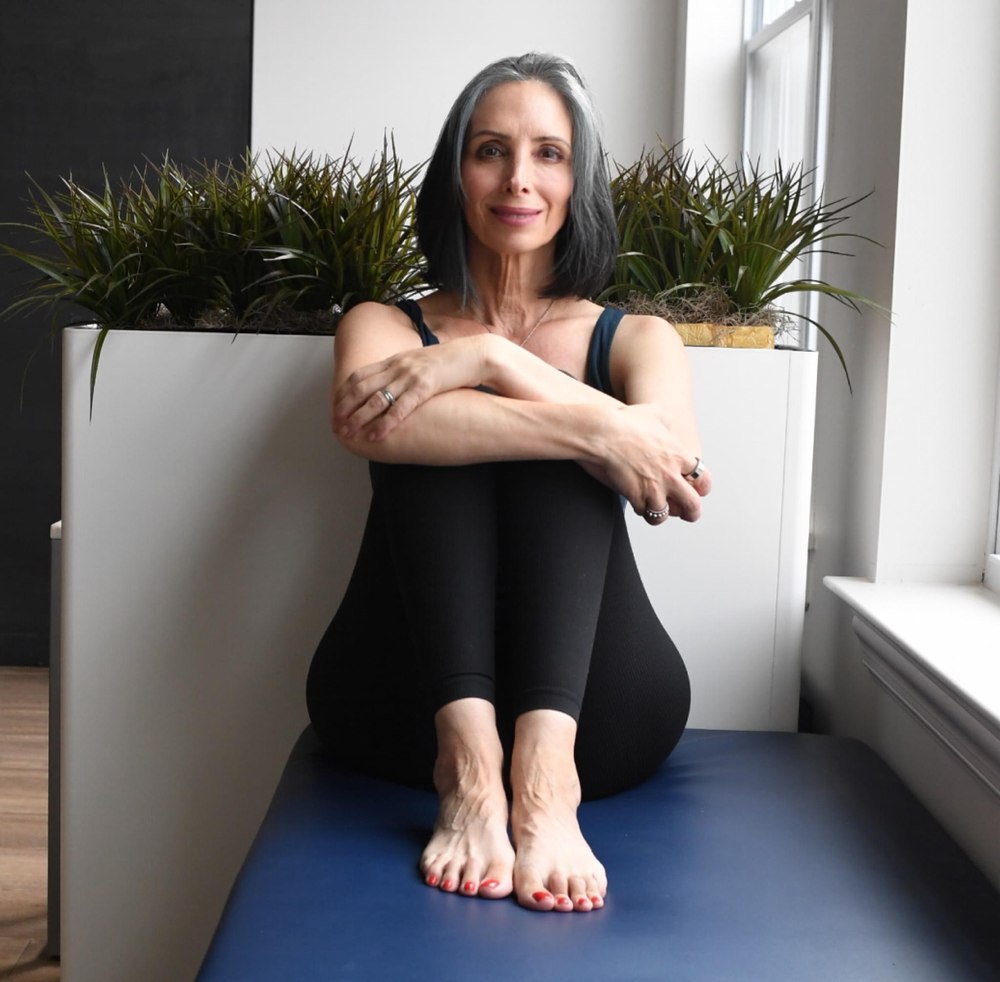 Gina Santangelo seated on the mat at the GLOW Body studio in Ridgewood, NJ