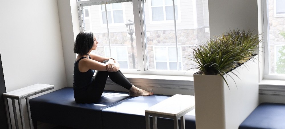 Gina Santangelo sitting by the windows at the GLOW Body studio in Ridgewood, NJ